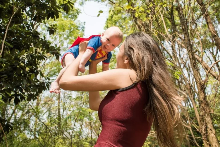 Madre levantando a su bebé al aire libre