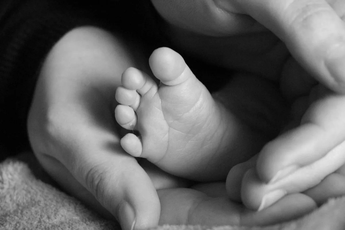 Burnout maternal: Cómo identificar el agotamiento emocional en la maternidad y qué hacer 1 Pies de un bebé en las manos de su madre