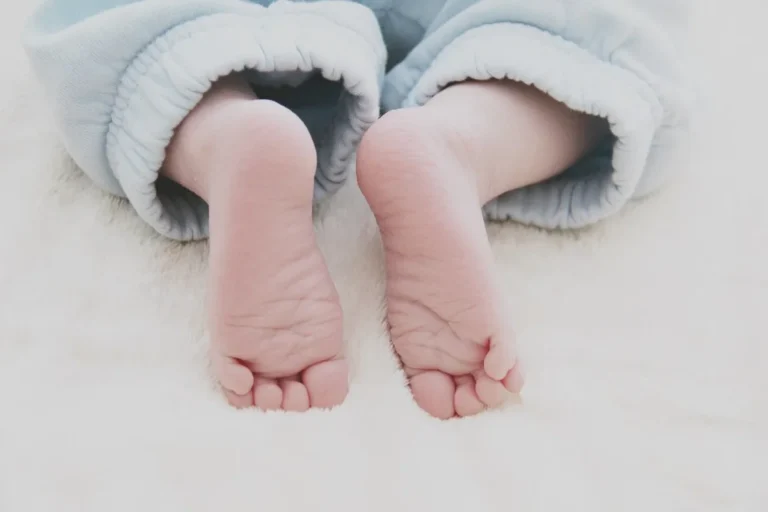 Pies de un bebé con pijama azul