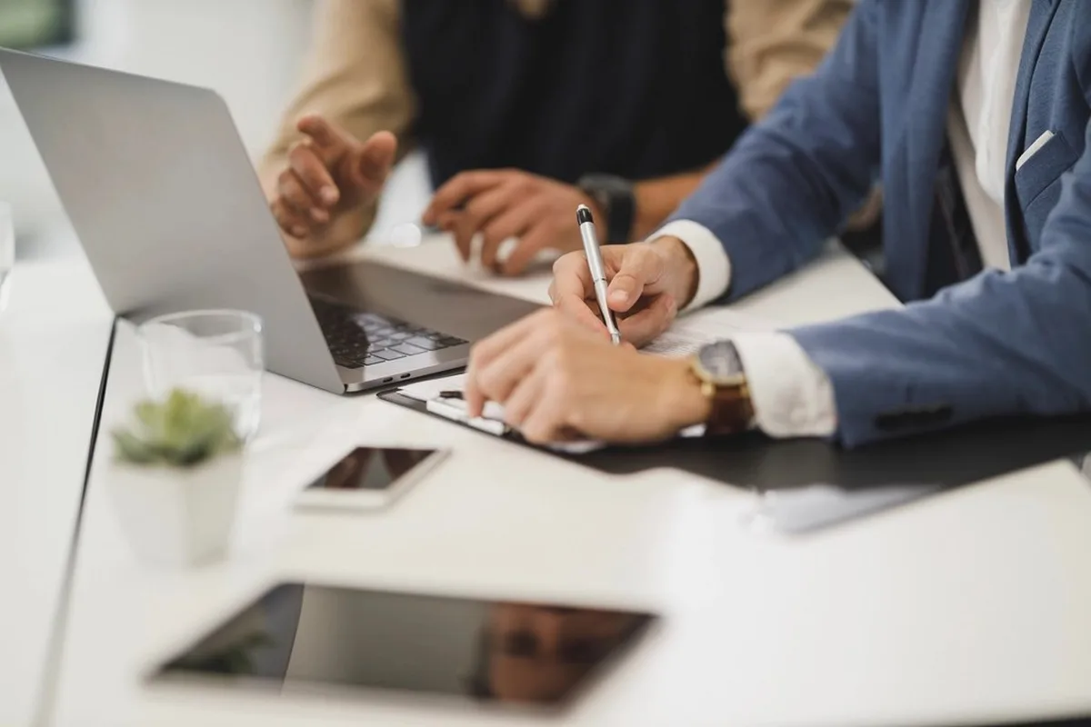 Persona revisando documentos con un portátil