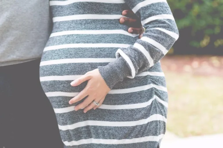 Pareja abrazando la barriga de embarazada